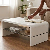 Arch High Gloss Coffee Table White with a glass shelf, person enjoying coffee while reading a book.